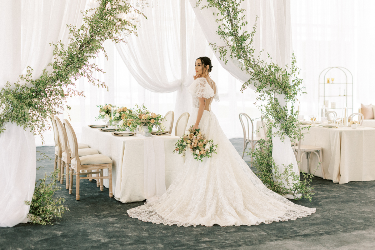 garland-draped-pergola-and-bride-with-neutrals-bouquet